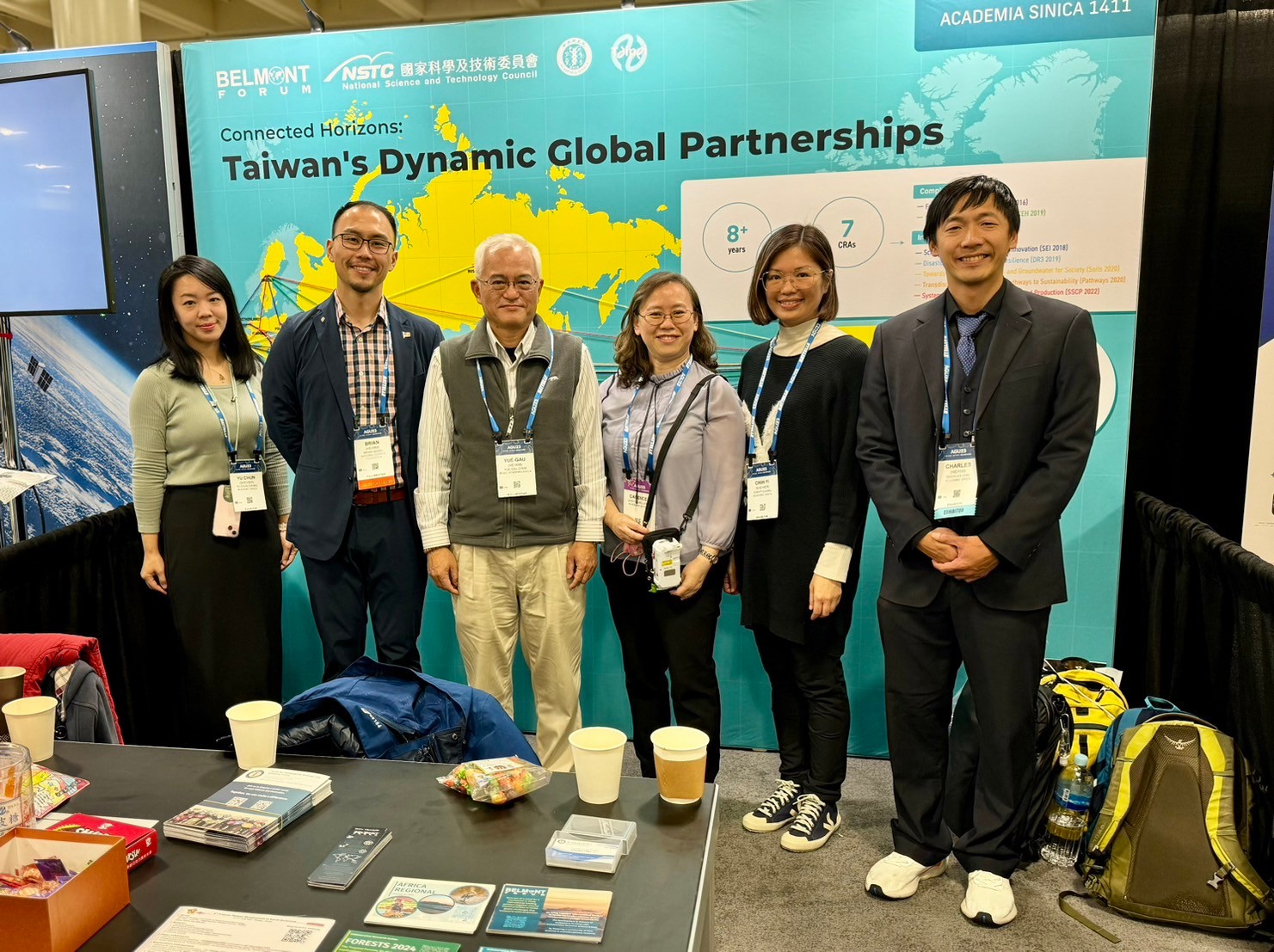 AGU23 舊金山展會合照，工作人員於「Taiwan's Dynamic Global Partnerships」展位背板前拍照記錄。